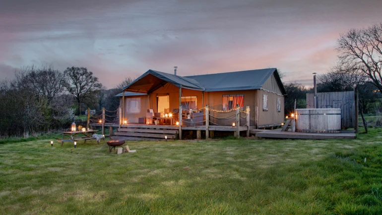 Glamping hut with hot tub in a field